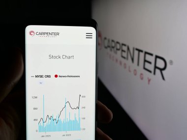 Stuttgart, Germany - 11-05-2025: Person holding cellphone with webpage of US company Carpenter Technology Corporation on screen in front of logo. Focus on center of phone display.