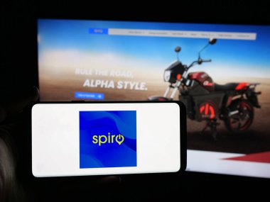 Stuttgart, Germany - 11-06-2025: Person holding smartphone with logo of Kenyan electric vehicle company Spiro on screen in front of website. Focus on phone display.