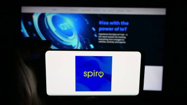 Stuttgart, Germany - 11-06-2025: Person holding cellphone with logo of Kenyan electric vehicle company Spiro on screen in front of webpage. Focus on phone display.