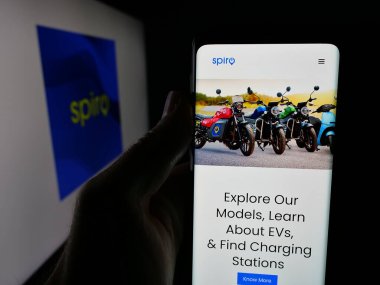 Stuttgart, Germany - 11-06-2025: Person holding smartphone with web page of Kenyan electric vehicle company Spiro on screen in front of logo. Focus on center of phone display.