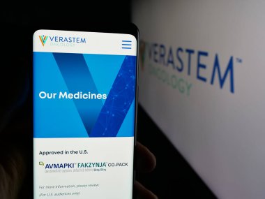 Stuttgart, Germany - 11-06-2025: Person holding cellphone with webpage of US oncology company Verastem Inc. on screen in front of logo. Focus on center of phone display.
