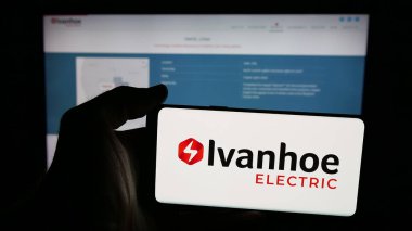 Stuttgart, Germany - 11-06-2025: Person holding mobile phone with logo of US minerals company Ivanhoe Electric Inc. on screen in front of web page. Focus on phone display.