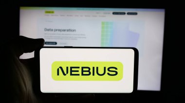 Stuttgart, Germany - 11-06-2025: Person holding cellphone with logo of AI infrastructure company Nebius Group N.V. on screen in front of webpage. Focus on phone display.