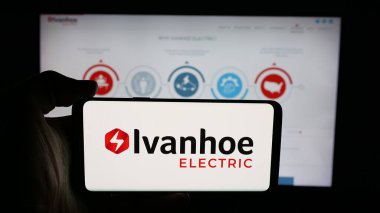 Stuttgart, Germany - 11-06-2025: Person holding cellphone with logo of US minerals company Ivanhoe Electric Inc. on screen in front of webpage. Focus on phone display.