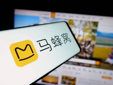 Stuttgart, Germany - 11-07-2025: Smartphone with logo of Chinese travel company Mafengwo.com on screen in front of website. Focus on center-left of phone display.