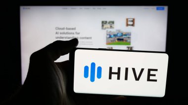 Stuttgart, Germany - 11-07-2025: Person holding mobile phone with logo of US AI company Castle Global Inc. (Hive) on screen in front of web page. Focus on phone display.