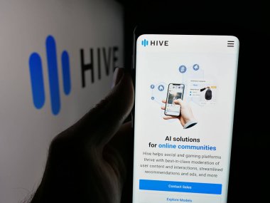 Stuttgart, Germany - 11-07-2025: Person holding smartphone with web page of US AI company Castle Global Inc. (Hive) on screen in front of logo. Focus on center of phone display.
