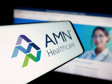 Stuttgart, Germany - 11-08-2025: Smartphone with logo of staffing company AMN Healthcare Services Inc. on screen in front of website. Focus on left of phone display.