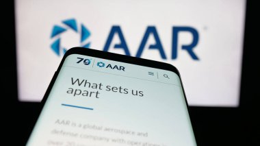 Stuttgart, Germany - 11-08-2025: Mobile phone with website of US aircraft maintenance company AAR Corp. on screen in front of logo. Focus on top-left of phone display.
