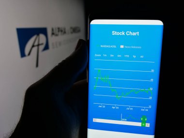 Stuttgart, Germany - 11-08-2025: Person holding smartphone with web page of company Alpha and Omega Semiconductor Limited on screen in front of logo. Focus on center of phone display.