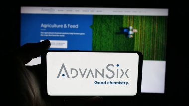Stuttgart, Germany - 11-12-2025: Person holding cellphone with logo of US chemical company AdvanSix Inc. on screen in front of webpage. Focus on phone display.