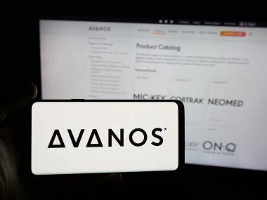 Stuttgart, Germany - 11-12-2025: Person holding smartphone with logo of US healthcare company Avanos Medical Inc. on screen in front of website. Focus on phone display.