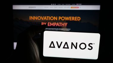Stuttgart, Germany - 11-12-2025: Person holding mobile phone with logo of US healthcare company Avanos Medical Inc. on screen in front of web page. Focus on phone display.