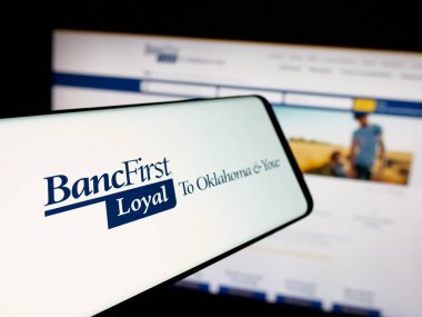 Stuttgart, Germany - 11-12-2025: Smartphone with logo of US financial company BancFirst Corporation on screen in front of website. Focus on center-left of phone display.