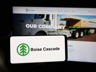 Stuttgart, Germany - 11-12-2025: Person holding smartphone with logo of US wood company Boise Cascade Company on screen in front of website. Focus on phone display.