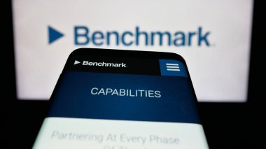Stuttgart, Almanya - 11-13-2025: ABD 'li Benchmark Electronics Inc. şirketinin web sitesinin bulunduğu cep telefonu logonun önünde ekranda. Telefon ekranının sol üst kısmına odaklan.