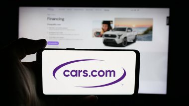 Stuttgart, Almanya - 11-14-2025: Otomotiv sınıflandırma şirketi Cars.com Inc. 'nin logosuna sahip cep telefonu web sayfası önünde ekranda. Telefon ekranına odaklan.