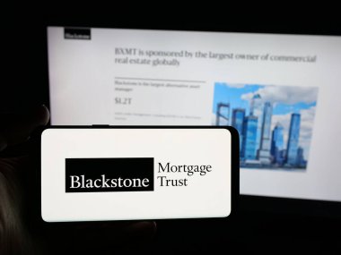 Stuttgart, Almanya - 11-14-2025: ABD 'li Blackstone Mortgage Trust Inc. şirketinin logosunu elinde tutan kişi web sitesinin önünde ekranda. Telefon ekranına odaklan.