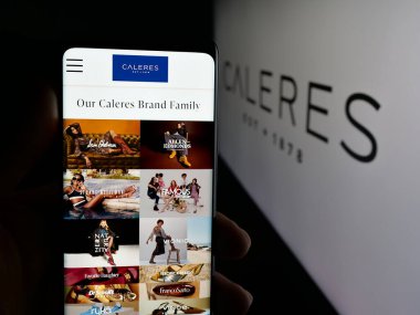 Stuttgart, Almanya - 11-14-2025: ABD 'li ayakkabı şirketi Caleres Inc.' in web sayfası ile akıllı telefonu olan kişi logonun önünde ekranda. Telefon ekranının merkezine odaklan.
