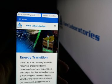 Stuttgart, Almanya - 11-14-2025: Petrol hizmetleri şirketi NV 'nin web sayfası ile akıllı telefonu olan kişi logonun önünde ekranda. Telefon ekranının merkezine odaklan.