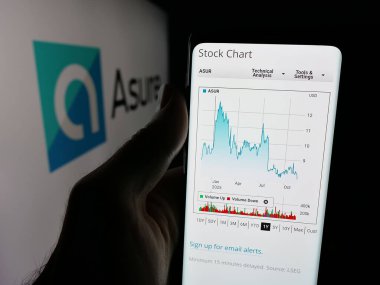 Stuttgart, Almanya - 11-18-2025: ABD 'li Asure Software Inc. şirketinin web sayfası ile akıllı telefon sahibi kişi logonun önünde ekranda. Telefon ekranının merkezine odaklan.