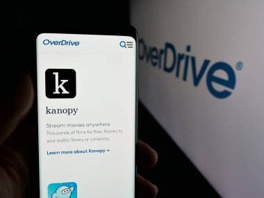 Stuttgart, Almanya - 11-19-2025: ABD 'li medya dağıtım şirketi OverDrive Inc.' in web sayfası ile akıllı telefon sahibi kişi logonun önünde ekranda. Telefon ekranının merkezine odaklan.