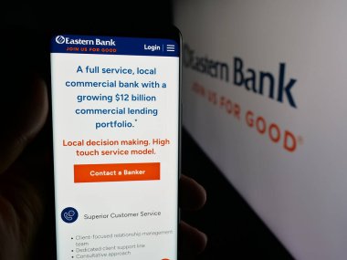 Stuttgart, Almanya - 11-19-2025: ABD 'li bankacılık şirketi Eastern Bancshare Inc.' in internet sayfası olan cep telefonu logosu önünde ekranda. Telefon ekranının merkezine odaklan.