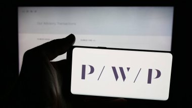 Stuttgart, Almanya - 11-19-2025: Web sayfası önünde ekranda ABD 'li Perella Weinberg Partners (PWP) logosunun bulunduğu cep telefonu sahibi kişi. Telefon ekranına odaklan.