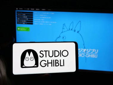 Stuttgart, Almanya - 11-20-2025: Japon anime şirketi K.K. 'nin logosunu taşıyan kişi Studio Ghibli web sitesinin önünde ekranda. Telefon ekranına odaklan.