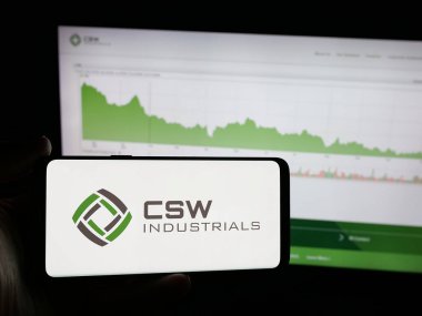 Stuttgart, Almanya - 11-20-2025: ABD 'li CSW Industrials Inc. şirketinin logosunu elinde tutan kişi web sitesinin önünde ekranda. Telefon ekranına odaklan.