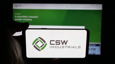 Stuttgart, Almanya - 11-20-2025: ABD 'li CSW Industrials Inc. şirketinin logosunun bulunduğu cep telefonu web sayfası önünde ekranda. Telefon ekranına odaklan.