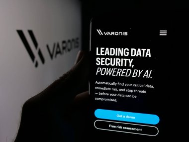 Stuttgart, Almanya - 11-21-2025: ABD 'li yazılım şirketi Varonis Systems Inc.' in web sayfası ile akıllı telefon sahibi kişi logonun önünde ekranda. Telefon ekranının merkezine odaklan.