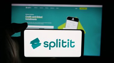 Stuttgart, Almanya - 11-21-2025: Satın alma logosu olan cep telefonu sahibi kişi daha sonra Splitit USA Inc. şirketini web sayfasının önünde ekranda görüyor. Telefon ekranına odaklan.