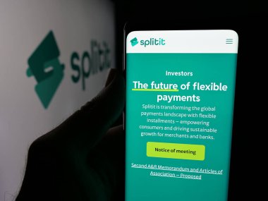 Stuttgart, Almanya - 11-21-2025: Akıllı telefonu elinde tutan kişi web sitesi ile satın alma için ödeme yapıyor. Splitit USA Inc., ekranda logo önünde. Telefon ekranının merkezine odaklan.
