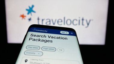 Stuttgart, Almanya - 11-21-2025: ABD 'li çevrimiçi seyahat şirketi Travelocity' nin web sitesiyle birlikte cep telefonu logonun önünde ekranda. Telefon ekranının sol üst kısmına odaklan.