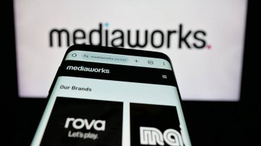 Stuttgart, Almanya - 11-21-2025: Medya şirketi MediaWorks Yeni Zelanda 'nın web sitesiyle birlikte cep telefonu logonun önünde ekranda. Telefon ekranının sol üst kısmına odaklan.