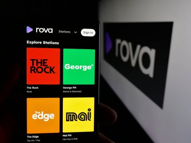 Stuttgart, Almanya - 11-21-2025: Yeni Zelanda yayın hizmeti şirketi Rova 'nın internet sayfası ile cep telefonu tutan kişi logonun önünde ekranda. Telefon ekranının merkezine odaklan.