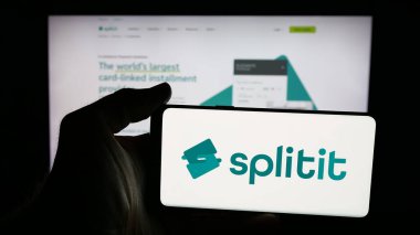 Stuttgart, Almanya - 11-21-2025: Satın alma logosu olan cep telefonu sahibi kişi daha sonra Splitit USA Inc. adlı şirketi web sayfasının önünde ekranda. Telefon ekranına odaklan.