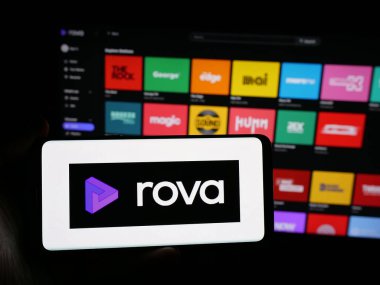 Stuttgart, Almanya - 11-21-2025: Elinde Yeni Zelanda yayın servisi Rova 'nın logosunun bulunduğu akıllı telefon bulunan kişi web sitesinin önünde ekranda. Telefon ekranına odaklan.