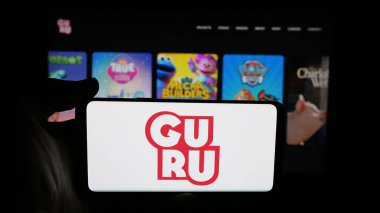 Stuttgart, Almanya - 11-23-2025: Kanada animasyon stüdyo şirketi Guru 'nun logosunun bulunduğu cep telefonu web sayfası önünde ekranda. Telefon ekranına odaklan.