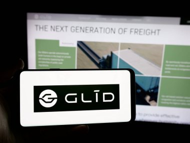 Stuttgart, Almanya - 11-23-2025: ABD 'li Glid Technologies Corporation şirketinin logosunu elinde tutan kişi web sitesinin önünde ekranda. Telefon ekranına odaklan.