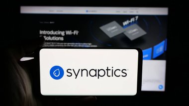 Stuttgart, Almanya - 11-24-2025: Web sayfası önünde ekranda ABD 'li sinir ağı şirketi Synaptics Inc.' in logosunun bulunduğu cep telefonu sahibi kişi. Telefon ekranına odaklan.