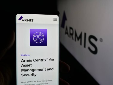 Stuttgart, Almanya - 11-24-2025: ABD 'li siber güvenlik şirketi Armis Inc.' nin internet sayfası ile cep telefonu tutan kişi logonun önünde ekranda. Telefon ekranının merkezine odaklan.