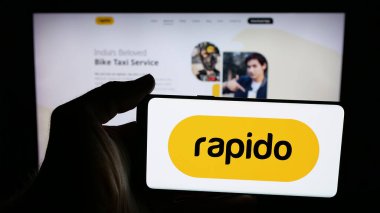 Stuttgart, Almanya - 11-24-2025: Hintli araç dolu şirketi Rapido 'nun logosunu taşıyan cep telefonu web sitesinin önünde. Telefon ekranına odaklan.