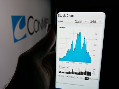 Stuttgart, Almanya - 11-26-2025: Tıbbi ekipman firması CONMED Corporation 'ın web sayfası olan akıllı telefon sahibi kişi logonun önünde ekranda. Telefon ekranının merkezine odaklan.