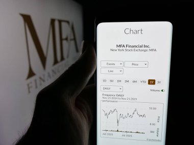Stuttgart, Almanya - 11-26-2025: ABD 'li finans şirketi MFA Financial Inc.' in web sayfası ile akıllı telefon sahibi kişi logo önünde ekranda. Telefon ekranının merkezine odaklan.