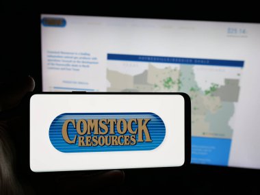 Stuttgart, Almanya - 11-26-2025: ABD 'li enerji şirketi Comstock Resources Inc.' in logosunu elinde tutan kişi web sitesinin önünde ekranda. Telefon ekranına odaklan.