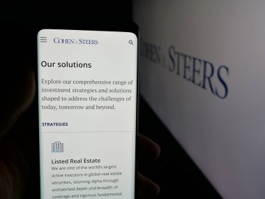 Stuttgart, Almanya - 11-26-2025: ABD 'li yatırım şirketi Cohen and Steers Inc.' in web sayfası olan cep telefonu logonun önünde ekranda. Telefon ekranının merkezine odaklan.
