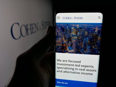 Stuttgart, Almanya - 11-26-2025: ABD 'li yatırım şirketi Cohen and Steers Inc.' in web sayfası ile akıllı telefon sahibi kişi logonun önünde ekranda. Telefon ekranının merkezine odaklan.