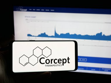 Stuttgart, Almanya - 11-26-2025: İnternet sitesi önünde üzerinde ABD 'li ilaç şirketi Corcept Therapeutics Inc.' in logosu bulunan akıllı telefon sahibi kişi. Telefon ekranına odaklan.